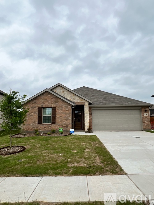 A house with a grey garage door and a brown brick exterior.
