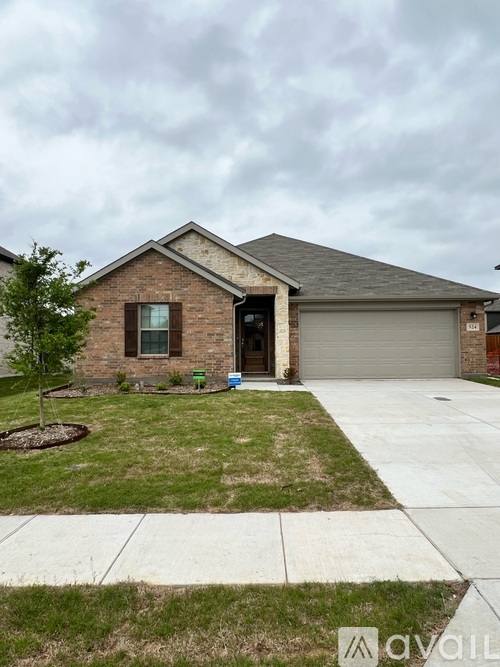 A house with a grey garage door and a brown brick exterior.