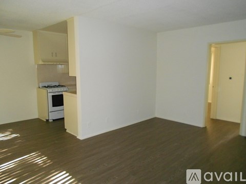 A room with a kitchenette and a microwave in it.