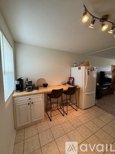 A kitchen with white cabinets and a white fridge.