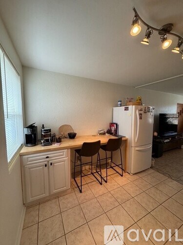 A kitchen with white cabinets and a white fridge.