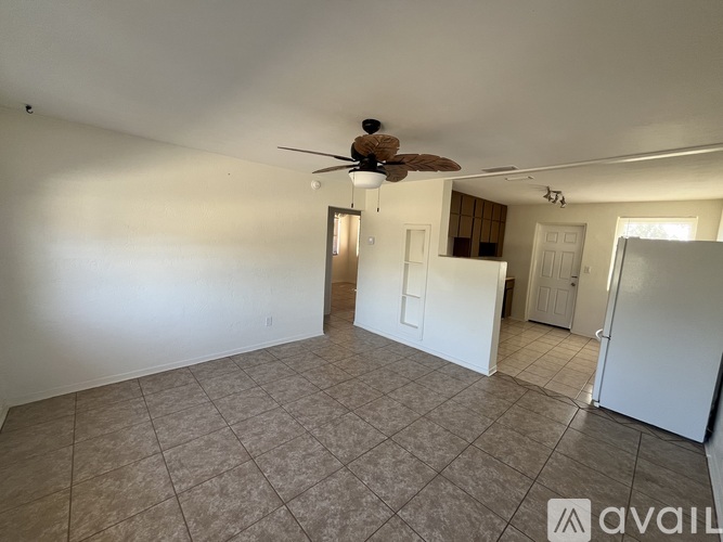 A room with a ceiling fan and tiled floor.