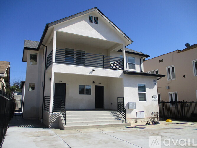 A two-story house with a balcony on the second floor.