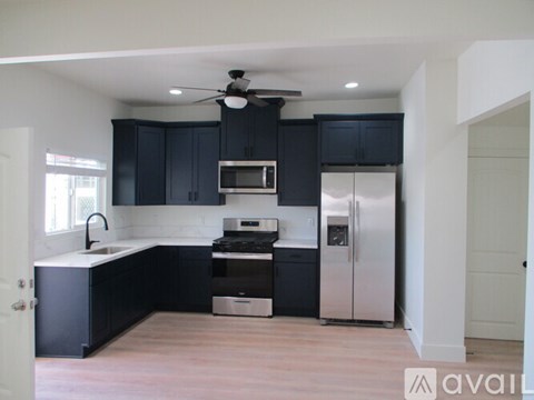 A kitchen with black cabinets and stainless steel appliances.