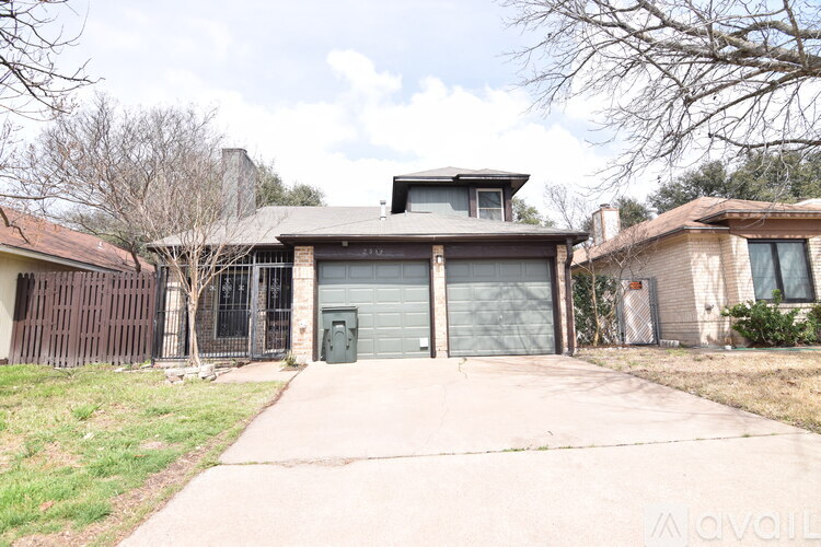 A house with a garage and a driveway in front of it.