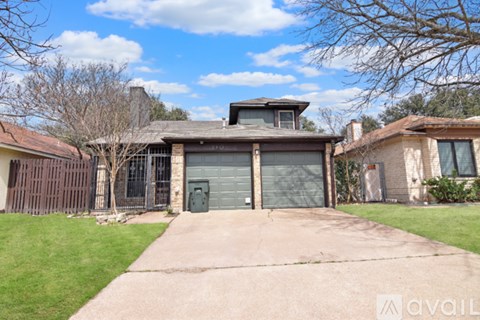 A house with a garage and a driveway in front of it.