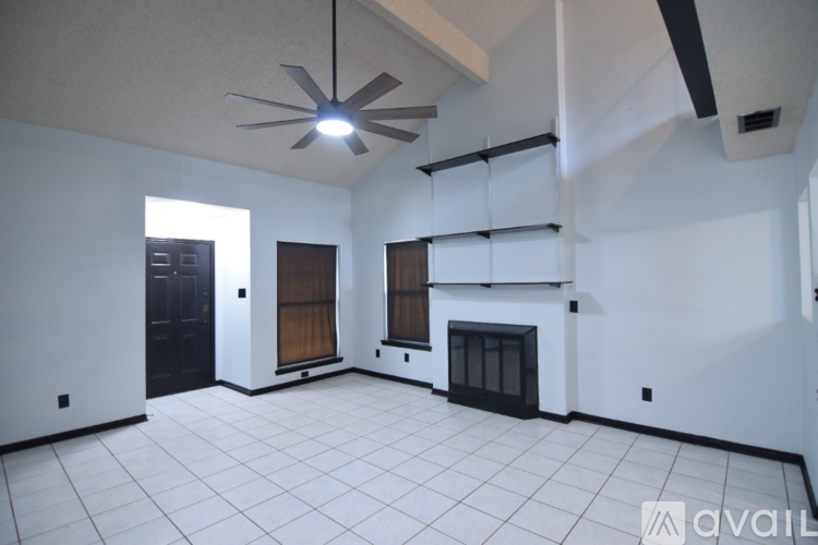A spacious living room with a fireplace and a balcony.