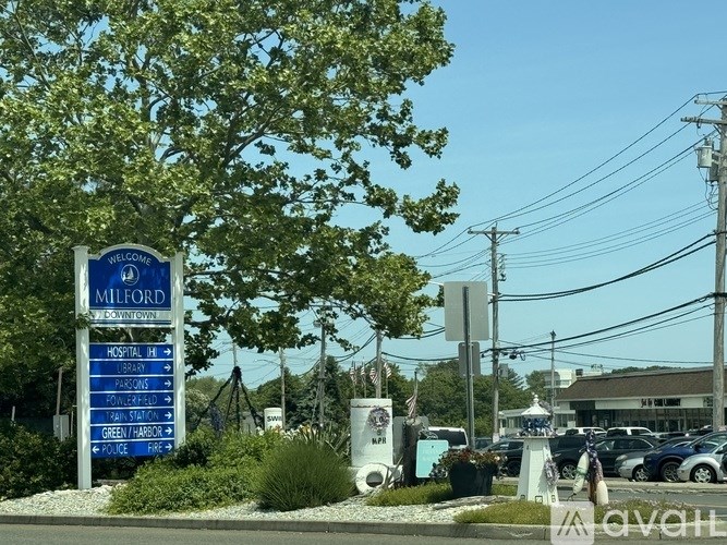 A sign welcoming visitors to Milford with various points of interest listed.