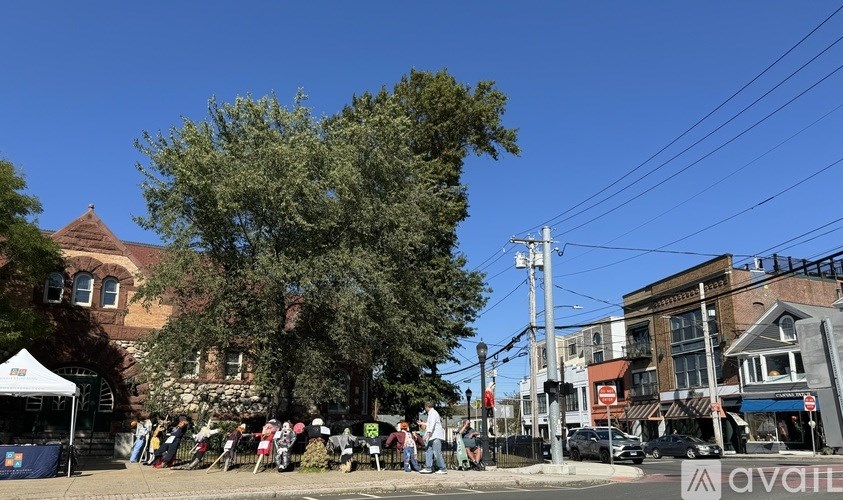 A group of people are gathered in front of a white tent on a sunny day.
