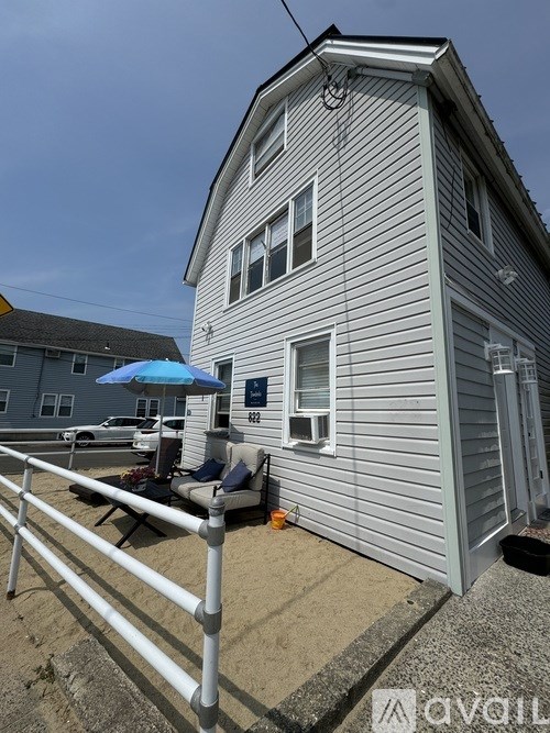 A house with a white fence and a blue umbrella.