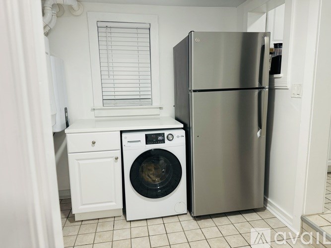 A white washing machine and fridge in a kitchen.