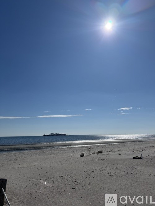 A beach scene with a bright sun in the sky.