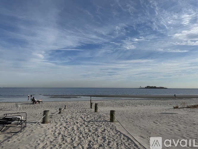 A beach scene with people and a small island in the distance.