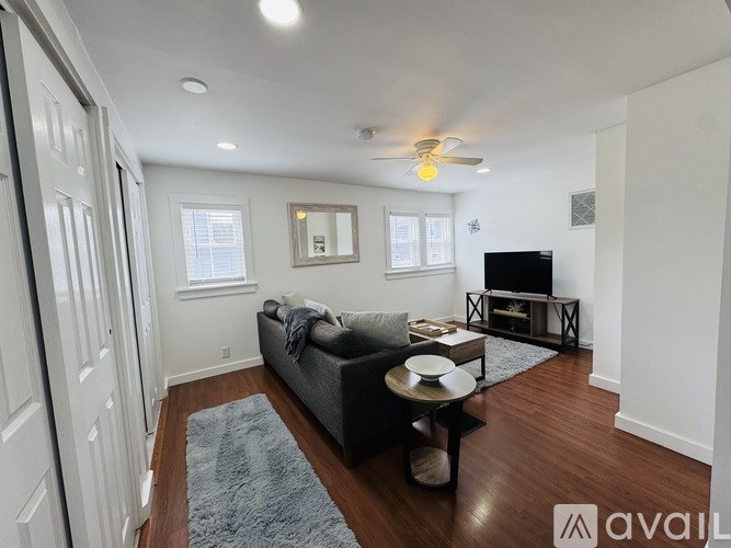 A living room with a grey couch, a coffee table, and a fireplace.