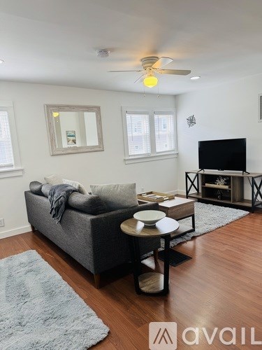 A living room with a grey couch, a coffee table, and a television.