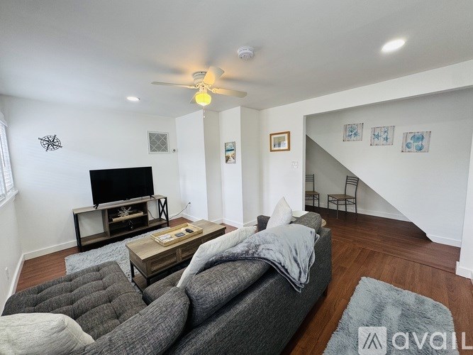 A living room with a grey couch and a television.