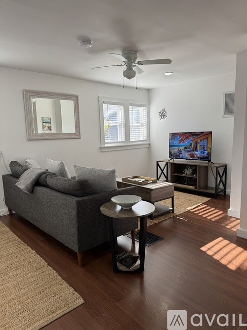 A living room with a grey couch and a wooden coffee table.