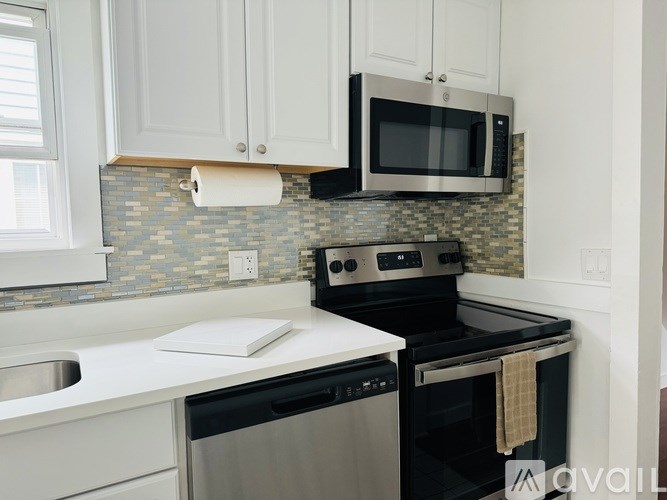 A kitchen with a black oven and white countertops.