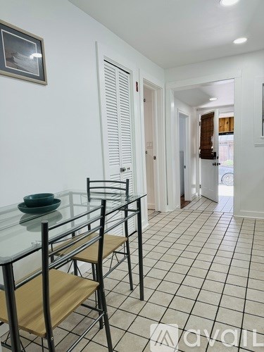 A dining room with a glass table and chairs.