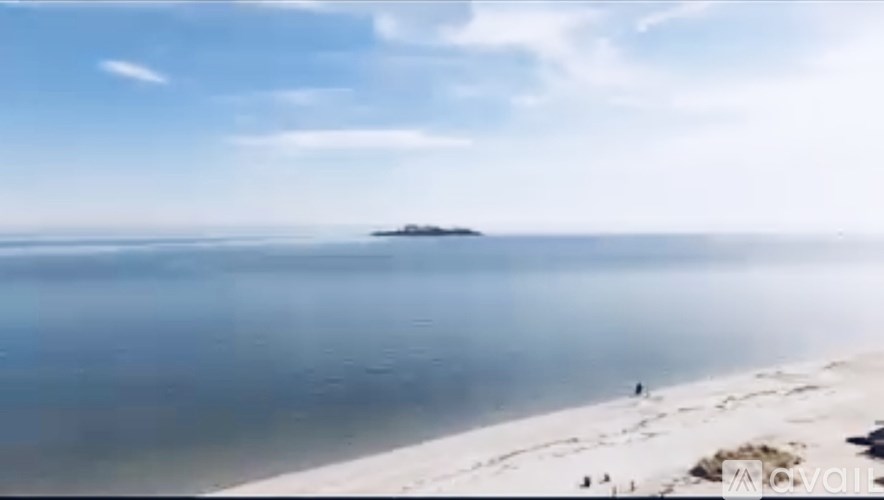 A small island is visible in the distance from a sandy beach.