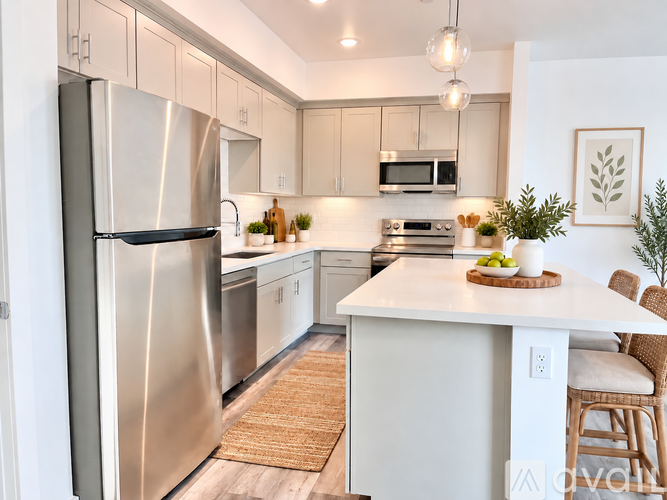 A kitchen with a stainless steel refrigerator and white cabinets.