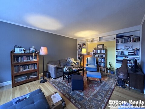 A living room with a couch, chair, and bookshelves.