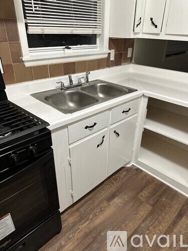 A kitchen with white cabinets and a black stove top oven.