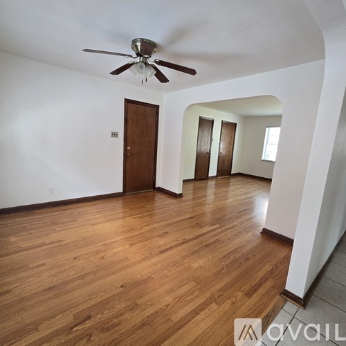 A room with wooden floors and a ceiling fan.