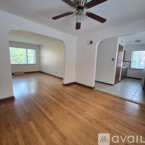 A room with wooden flooring and a ceiling fan.