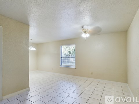 A room with a ceiling fan and a window.