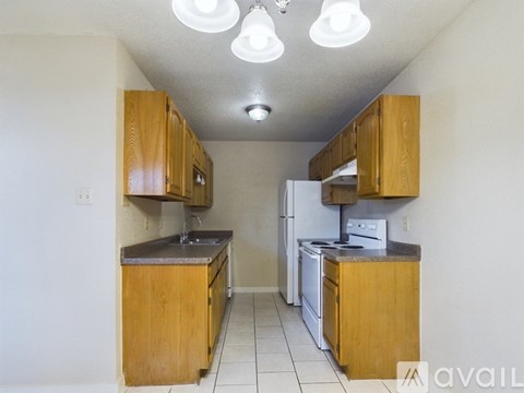 A kitchen with wooden cabinets and white appliances.