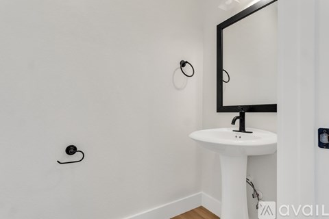 A white pedestal sink with a mirror above it.