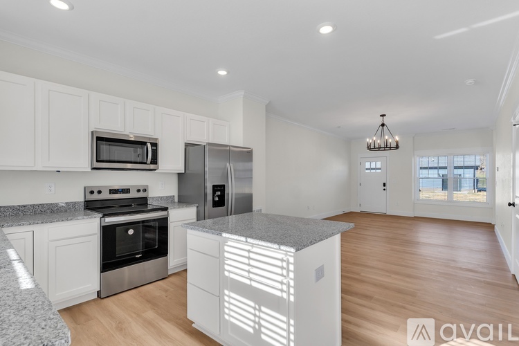 A kitchen with white cabinets and a granite countertop.