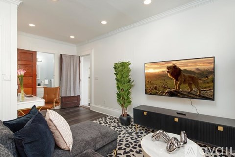 A living room with a large flat screen TV mounted on the wall.