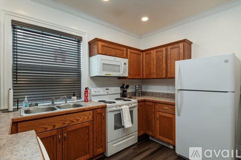 A kitchen with wooden cabinets and a white refrigerator.