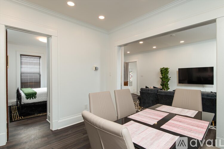 A living room with a couch, a chair, a dining table and a television.