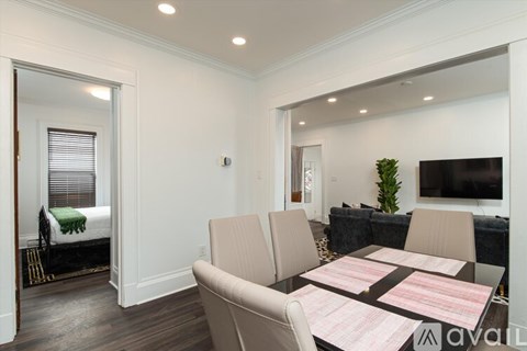 A living room with a couch, a chair, a dining table and a television.
