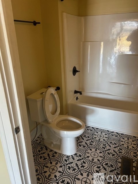 A white toilet in a bathroom with a black and white floor.