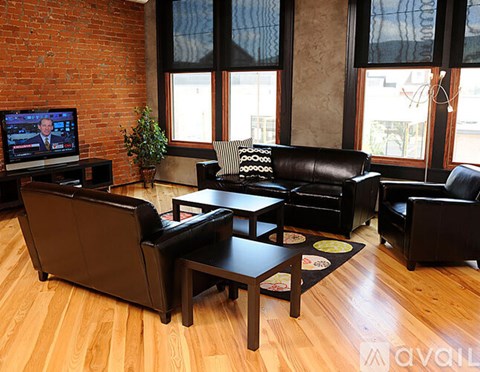A living room with a leather couch and a television.