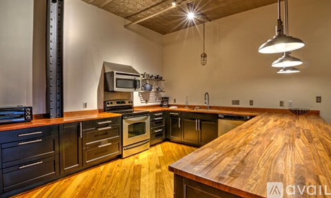 A modern kitchen with wooden countertops and stainless steel appliances.
