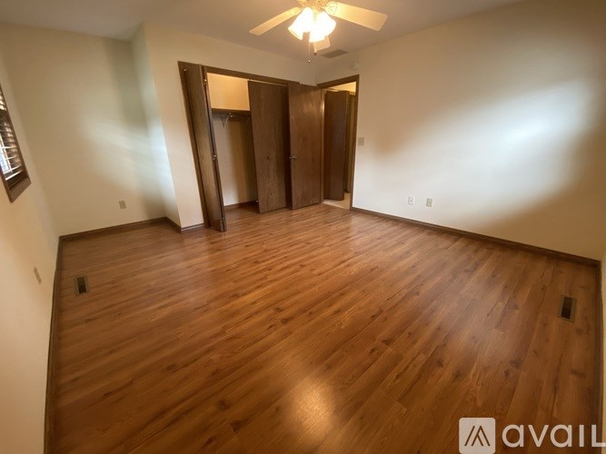 A room with wooden floors and a ceiling fan.