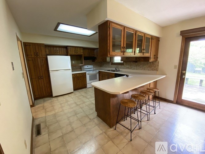 A kitchen with a white fridge and wooden cabinets.