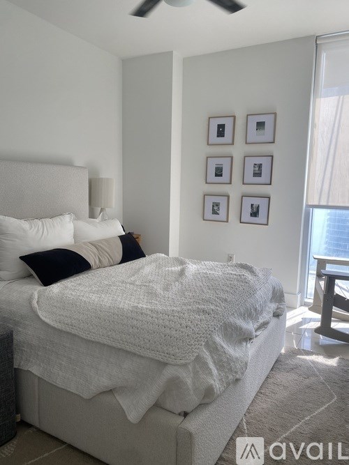 A bedroom with a large bed and a window overlooking the water.