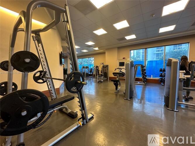 A gym with a variety of equipment including a weight bench, a leg press machine, and a squat rack.