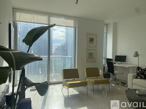 A living room with a yellow chair and a white couch.