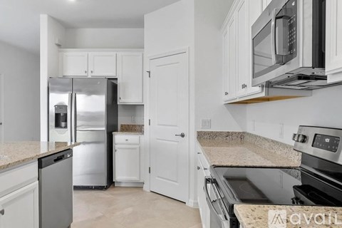 A kitchen with white cabinets and appliances.