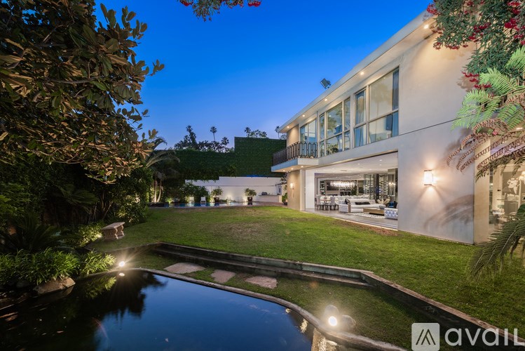 A house with a pool in front of it is available for rent.