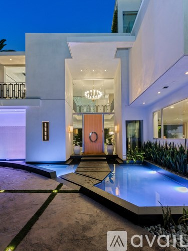 A modern house with a pool in the front yard.