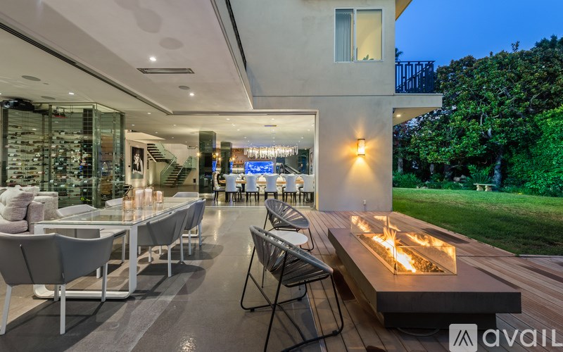 A modern outdoor seating area with a fire pit and chairs.
