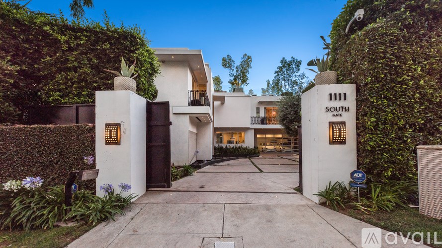 A modern house with a white exterior and a large driveway.